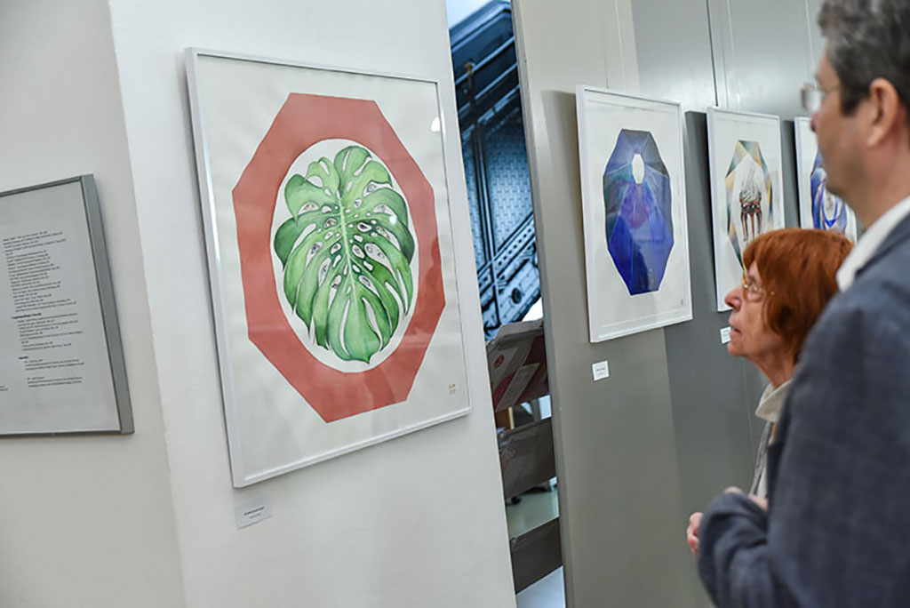 Zwei Besucher der Ausstellung betrachten das Bild „Ein Blatt namens Argus“