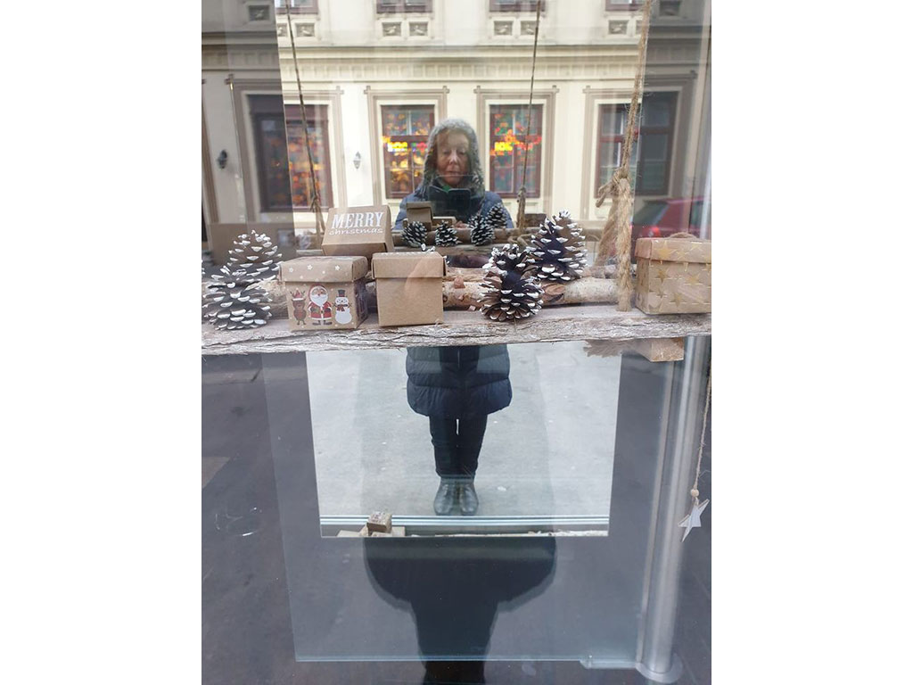 НинаВР фотографирует своё отражение в витрине магазина, двойное отражение